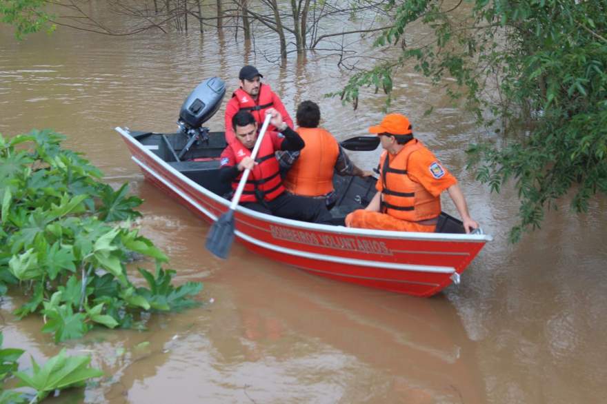 Bombeiros usaram barco para retirar moradora ilhada pela enchente