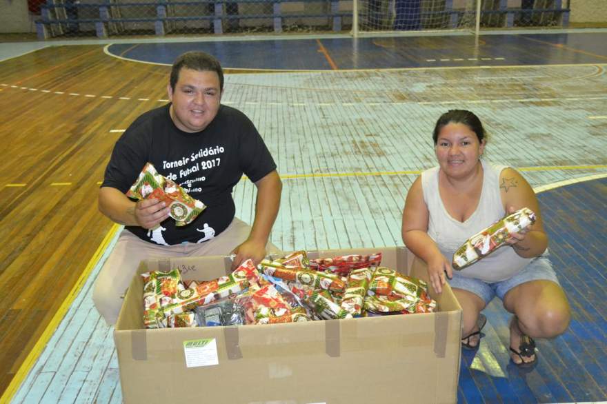 Daniel Santos e Lizie Nascimento com os brinquedos arrecadados no torneio beneficente de futsal