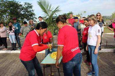 Participante descasca laranja para colega comer no circuito