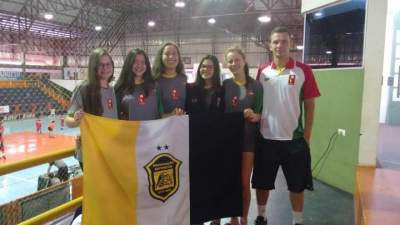 As atletas candelarienses e o técnico Ricardo Ellwanger com a bandeira do Flyboys no Paraná