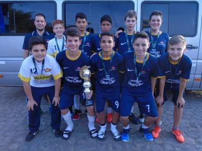 A equipe campeã, ao lado do professor Vinícius com a taça e as medalhas