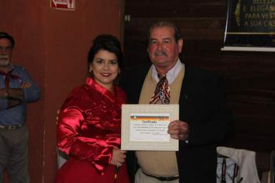 Aline Flores Steil entrega o certificado de sócio benemérito para Mauro Flores